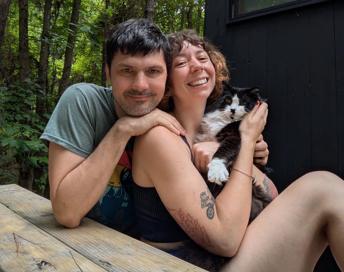 Luke, Moriah, and Bhatki the cat at a cabin in the woods